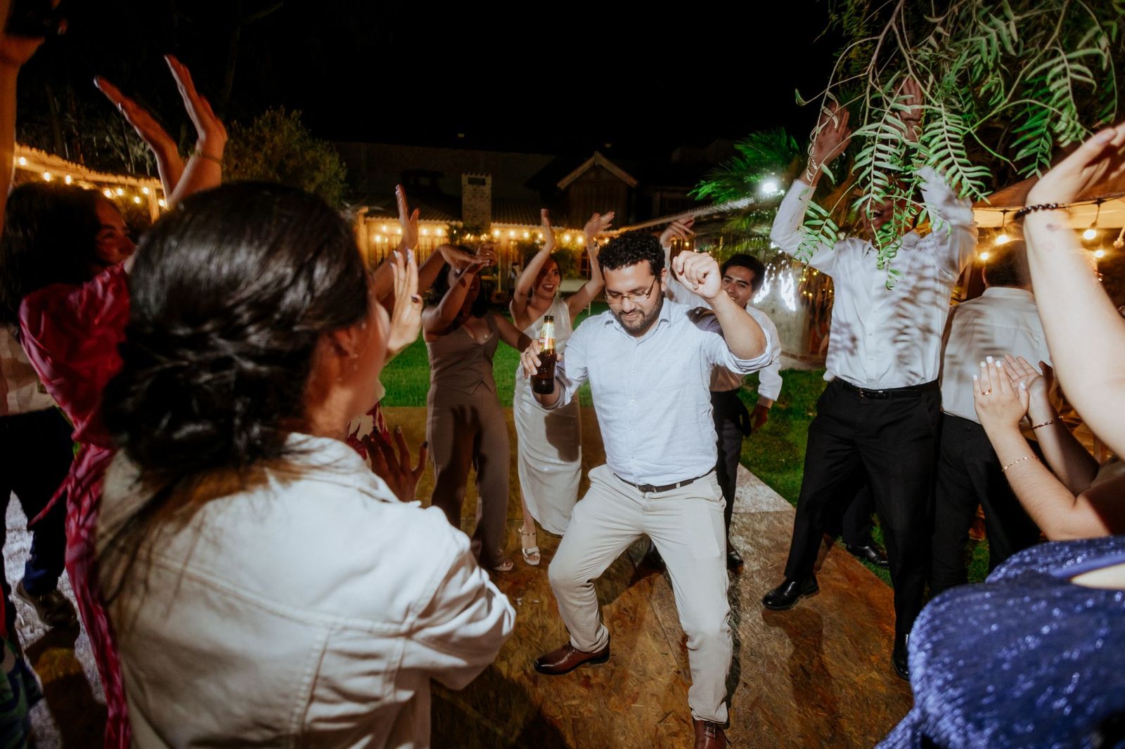 Guests dancing at an outdoor wedding party at night